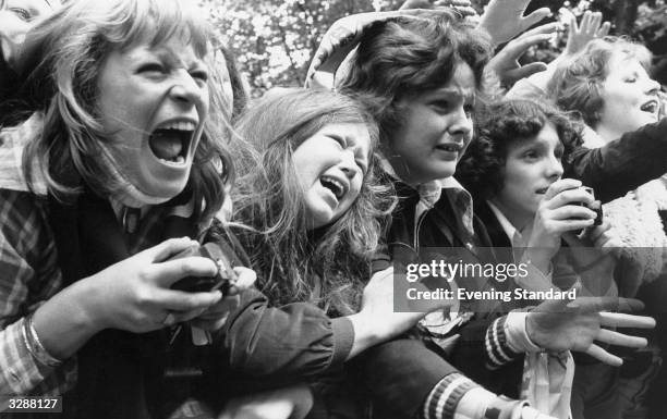 Crowd of over-excited teenage girls scream and cry at the sight of their idols, pop group The Osmonds.