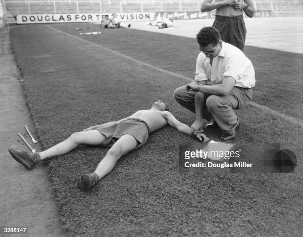 Dr Alan Bass checks the pulse of Tony Luckett, of Crystal Palace football team, during stamina tests at Selhurst Park.