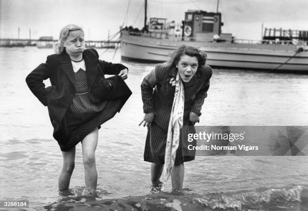 Two women find the water a little cold when paddling in the harbour at Southend.