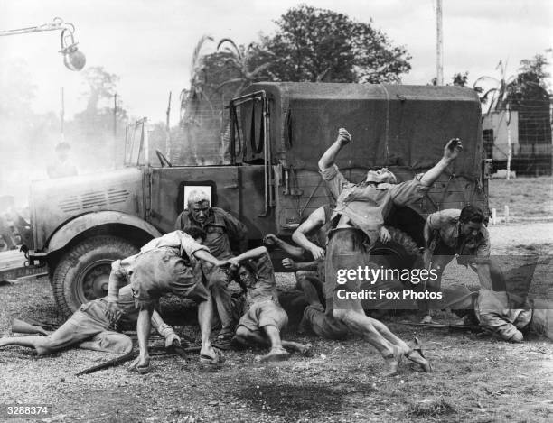 Actors playing the roles of prisoners and guards during the filming of a battle scene for the film 'The Camp On Blood Island', which tells the story...