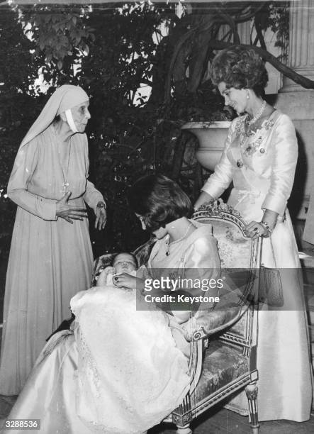 Baby Crown Princess Alexia of the Hellenes, in the arms of her mother, Queen Anne-Marie of the Hellenes, after her baptism in the royal palace at...