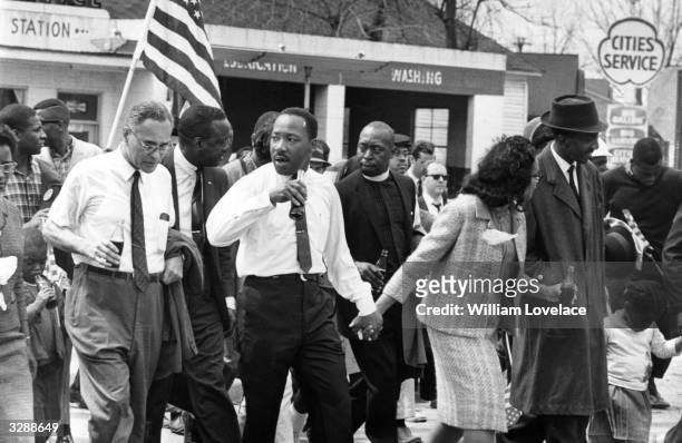 Martin Luther King and his wife Coretta Scott King lead a civil rights march from Selma, Alabama, to the state capital in Montgomery. On the left is...