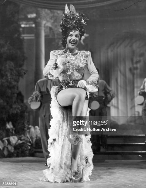 Brazilian singer and actress Carmen Miranda , known as the 'Brazilian Bombshell', in a scene from an unknown film.