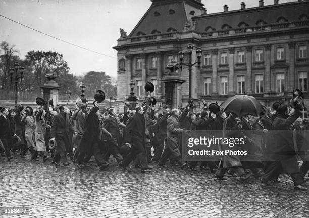 Ex-servicemen cheer King Leopold of Belgium as they march past the palace at Brussels.