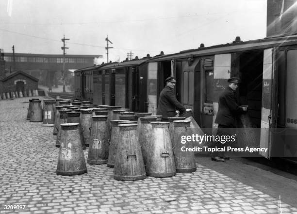 Railway porters load milk churns into the goods wagon on the North Staffordshire line.