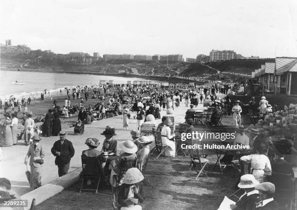 Crowds of promenaders and onlookers out on the Scarborough sea front.