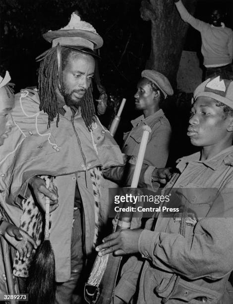 Kenyan revolutionary leader, Field Marshal Musa Mwariama of the Mau Mau movement, inspecting a final guard of honour at a forest base, before his...
