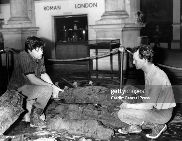 Peter Marsden, , an archaeologist with the Guildhall Museum, London, and Patrick Minns carry out some preparatory preservation work on a section of a...