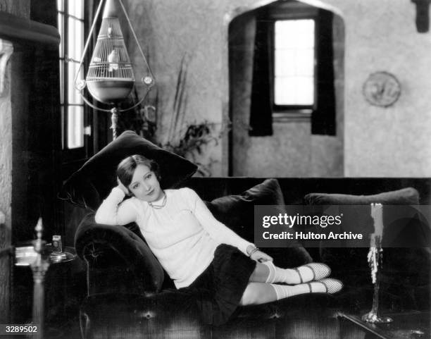 Bessie Love , the Hollywood actress who appeared in 'Dress Parade' relaxes in a chair in her Hollywood home.