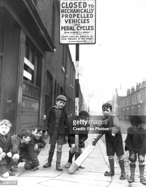 Children playing cricket in Salford in a street that has been closed to vehicular traffic.