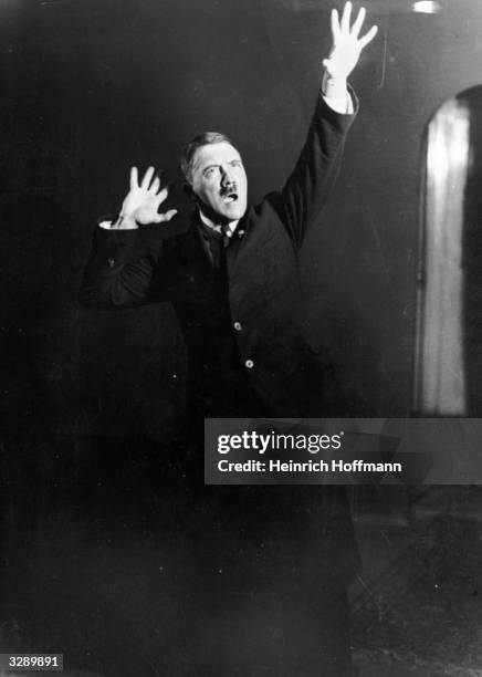 Adolf Hitler , leader of the National Socialist German Workers' Party , strikes a pose for photographer Heinrich Hoffmann whilst listening to a...