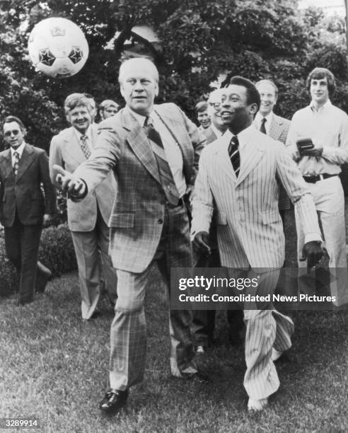 Brazilian footballer Pele jostling for the ball with Gerald Ford, 38th President of the United States, in the grounds of the White House, Washington.