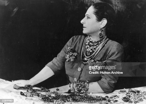 Beautician and business executive Helena Rubinstein modelling a selection of jewellery.
