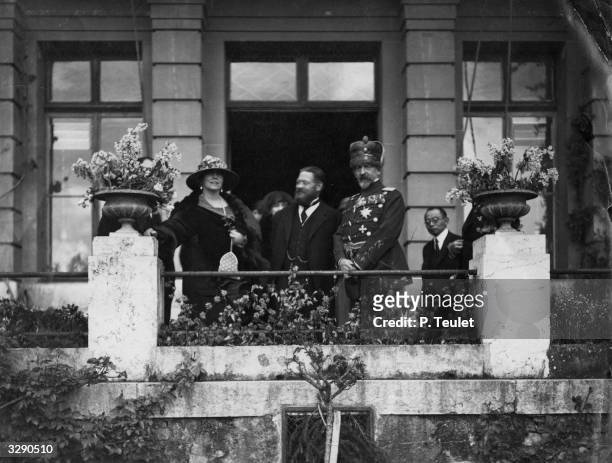 King Ferdinand I and Queen Marie of Romania with A Thomas, a director in the office of the League of Nations, in Geneva.