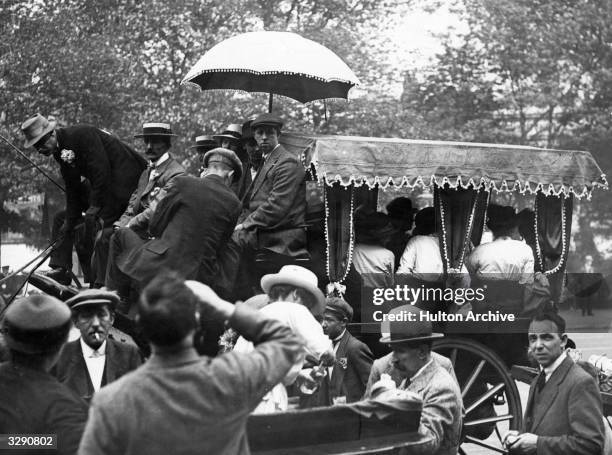 Coach on the Derby road with parasol and curtains overtakes an open cart.