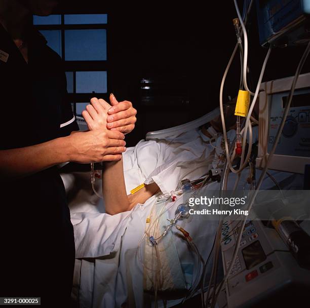 nurse checks patient's pulse - tod stock-fotos und bilder