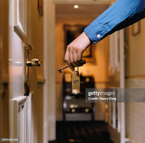 person with hotel door key - hotel key stock-fotos und bilder