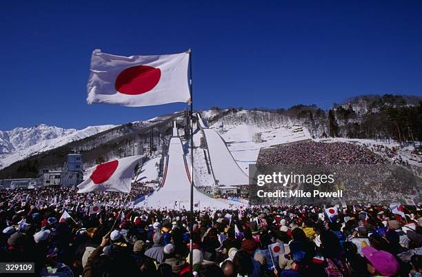 Japanese fans wave their flags at the ski jump venue of the nordic combined at Happo''One in Hakuba during the 1998 Winter Olympic Games in Nagano,...
