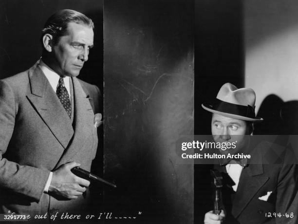 Jack Oakie , right, cowers behind a wall in the Paramount-Publix comedy 'Gang Buster', directed by A Edward Sutherland.