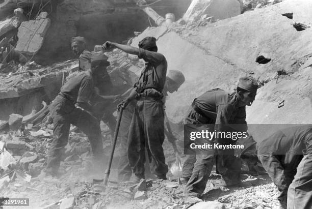 Soldiers work to clear debris in Skopje, Yugoslavia, following the earthquake which hit the town killing hundreds.