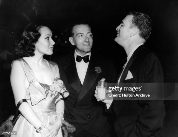 Actress Dolores Del Rio with her art director husband Cedric Gibbons, and Fritz Lang at the Rathbone party. Cedric designed the Oscar statuette for...