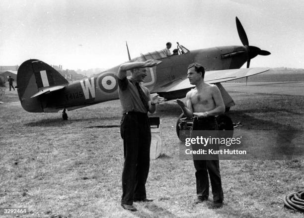 Group Captain Harry Day giving a few hints to English actor Kenneth More at RAF Kenley in Surrey. More is shortly to play British aviator Douglas...