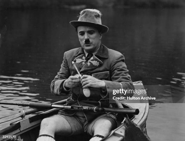 Charlie Chaplin sits in a boat in a scene from the United Artists film 'The Great Dictator', directed by Chaplin himself.
