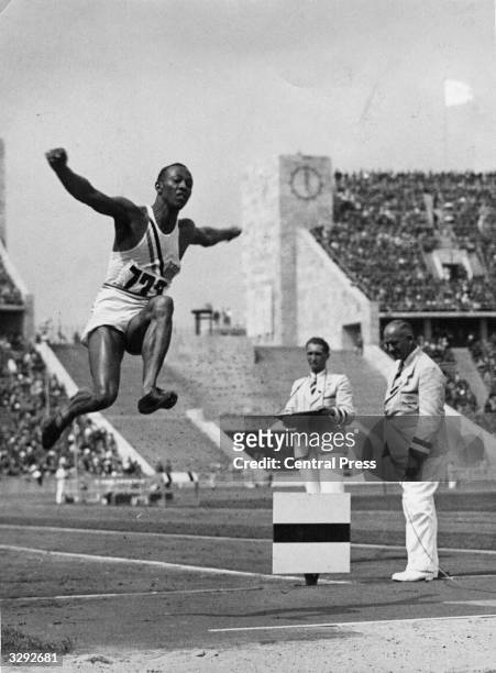 Athlete Jesse Owens flies through the air during the long jump event at the Olympic Games in Berlin. He won 4 gold medals and Hitler left the stadium...
