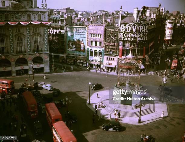 View of Piccadilly Circus, with decorations for the Coronation. The statue of Eros is enclosed in a birdcage structure for the celebrations.