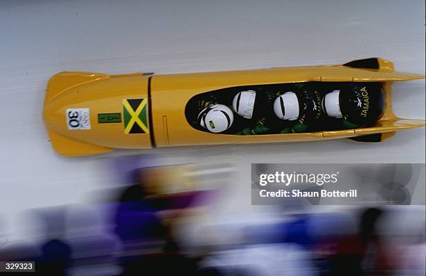 Dudley Stokes,Winston Watt,Nelson Stokes and Wayne Thomas of Jamaica compete in the four man bobsled competition at the Spiral during the 1998 Winter...