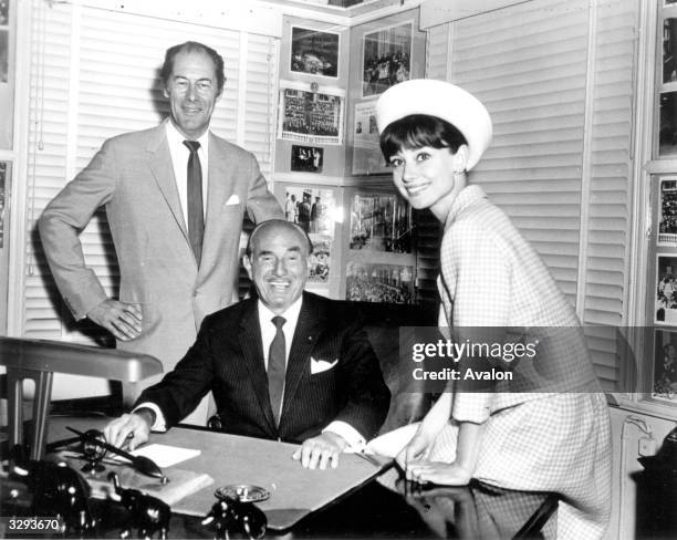 Audrey Hepburn with Rex Harrison in the office of Jack L Warner, head of Warner Brothers studios in Hollywood. Rex and Audrey have been signed for...