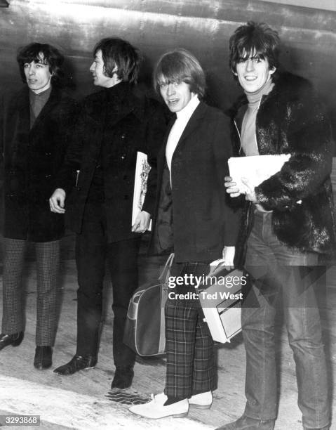 Four members of Britain's top pop group the Rolling Stones at London Airport. The band are travelling to the United States, where they are to appear...