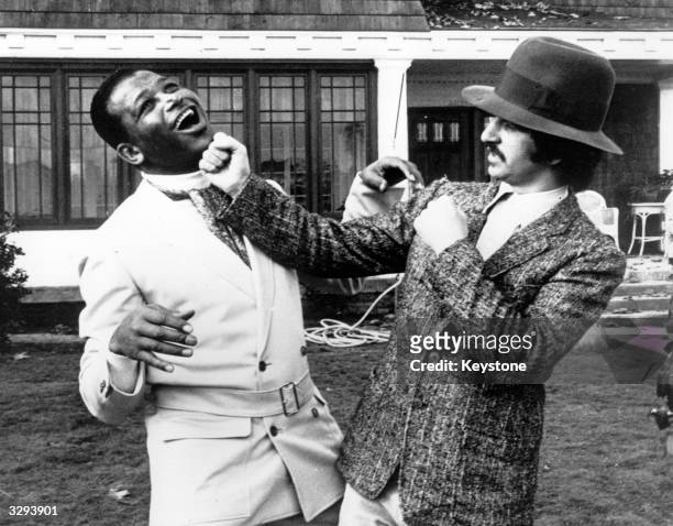 Beatles drummer Ringo Starr lays a punch on champion boxer Sugar Ray Robinson , in jest, during a break in the filming of 'Candy' which is being made...