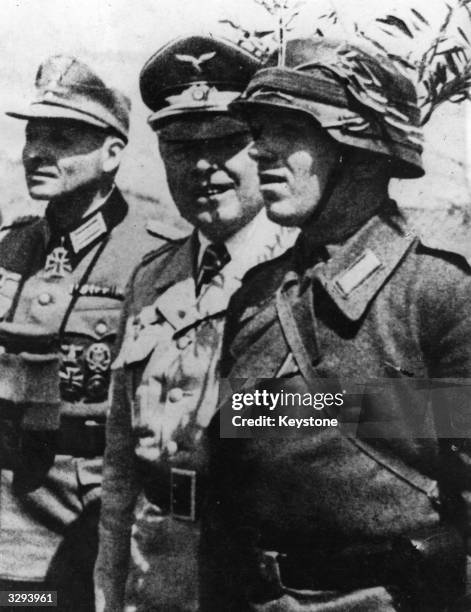 German Fieldmarshal Albert Kesselring, commander of Nazi forces in Italy, with an officer and a camouflaged soldier.