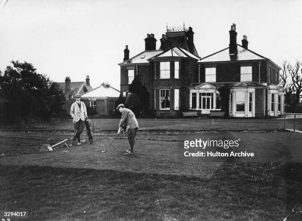 Golfers at the first tee at Bridlington golf course; the club house is in the background.