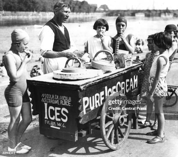 An ice cream seller sells ices to children by the Thames at Putney, London.