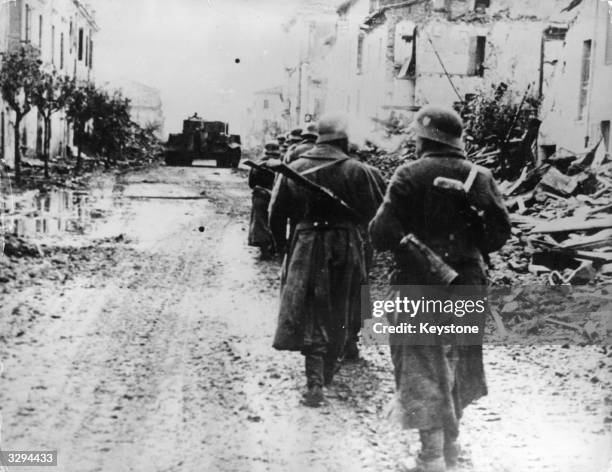 German 14th Army troops moving cautiously through an Italian village