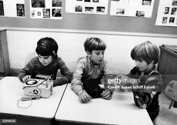 The young child on the left is examining a real geiger counter, whilst his colleagues compare their models with the real thing.