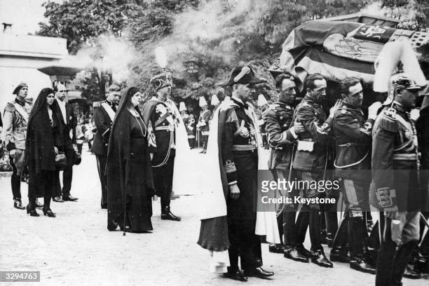 The coffin of Queen Marie of Romania being carried through Bucharest. Following it are King Carol II, his sister Elisabeth the ex-Queen of Greece,...