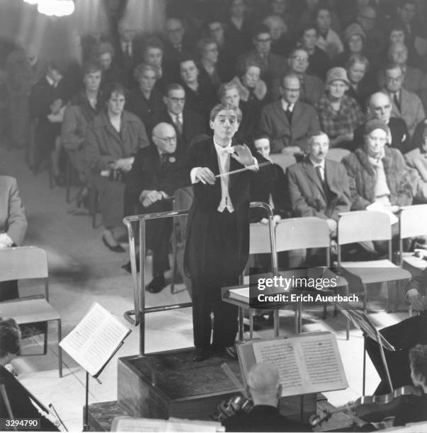 The English conductor and cellist Sir John Barbirolli , conducting the Halle Orchestra at Guildford Cathedral. He is the principal of the Halle...