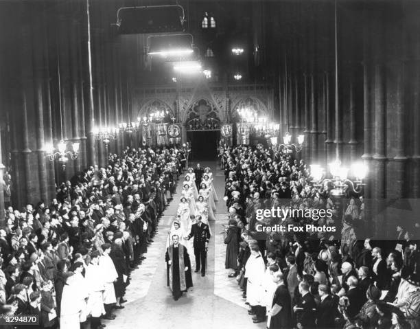 Queen Elizabeth II, as Princess Elizabeth, walks up the aisle of Westminster Abbey, London, with her father King George VI , to marry the Duke of...