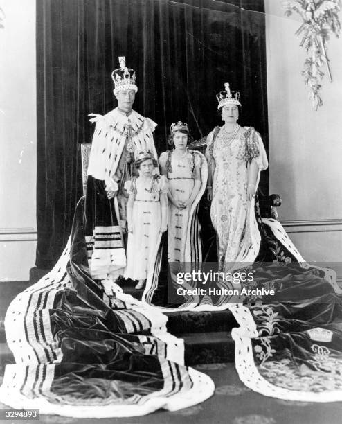 King George VI, and Queen Elizabeth with their daughters, Princesses Elizabeth and Margaret Rose in their coronation robes.