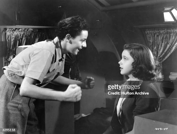 Freddie Bartholomew talks enthusiastically to Judy Garland in a scene from the film 'Listen, Darling', in which a group of children try to find their...