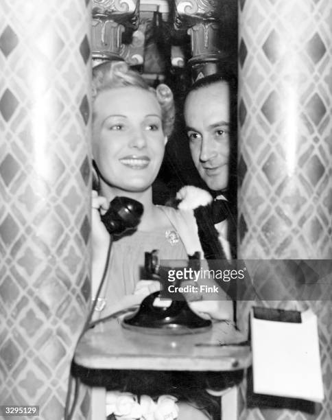 Binnie Barnes, seen here with director Jean Negulesco, making a telephone call somewhere in Hollywood.