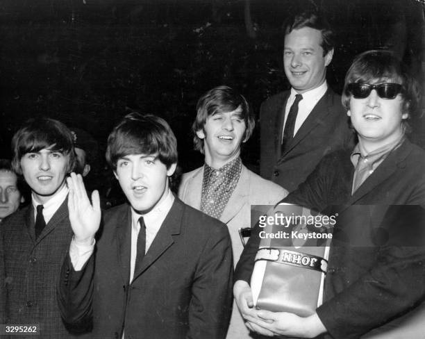 The Beatles, from left to right George Harrison , Paul McCartney, Ringo Starr, manager Brian Epstein , and John Lennon , at London Airport. They...