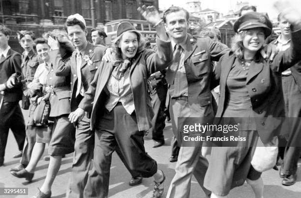 Happy group marches down a London street on VE Day. Original Publication: Picture Post - 1991 - This Was VE Day In London - pub. 1945