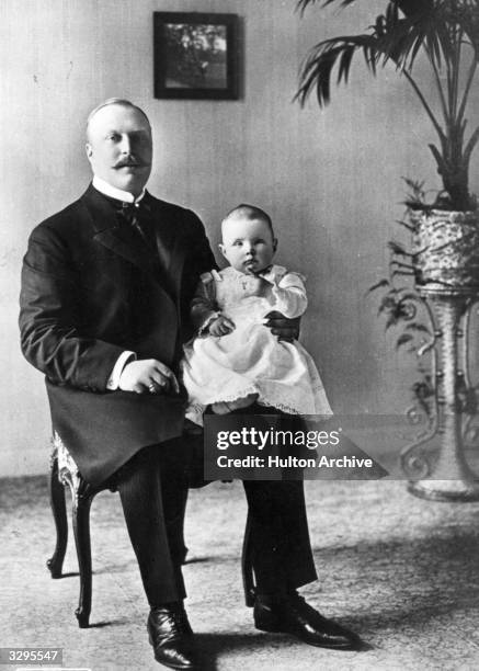 Queen Juliana of the Netherlands as a baby, on Prince Hendrik's knee.