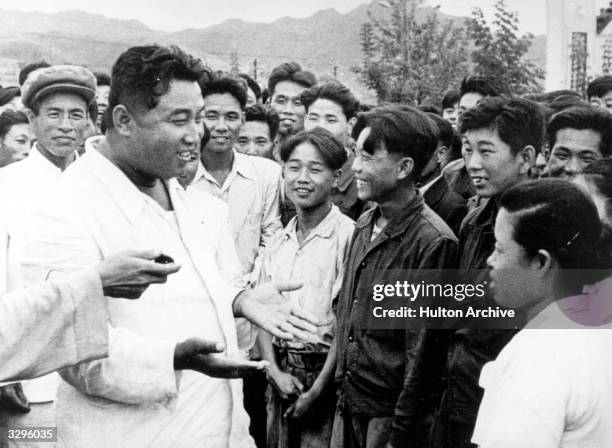 North Korean dictator, Kim Il Sung , chats with workers on an unofficial visit to the Hichun Machine Plant.