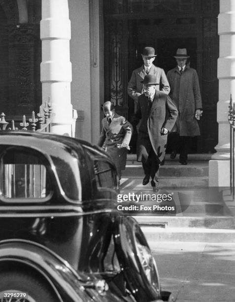 The 11 year old King Peter of Yugoslavia leaves the Yugoslavian Legation in London under guard for his school at Cobham.