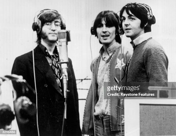 Three Beatles; from left to right John Lennon , George Harrison and Paul McCartney, record voices in a studio for their new cartoon film 'Yellow...